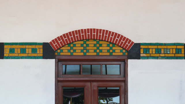 Architectural detail of a wooden door with decorative arched tile lintel