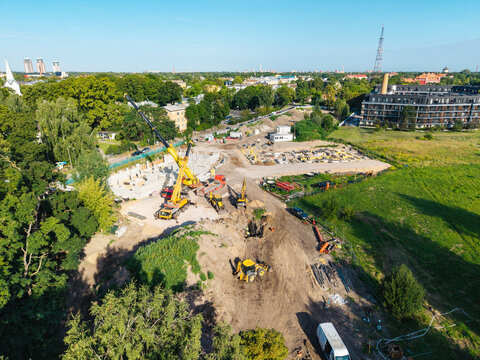 Riga, Latvia - 14 August 2026: Aerial view of a construction site at 4A Cieceres Street in Agenskalns, featuring heavy machinery, cranes, and earthworks on a sunny day.