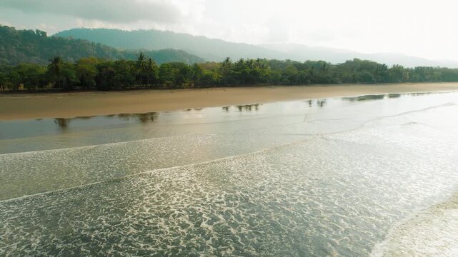 Aerial view of Playa Linda beach with mountains and palm trees in Costa Rica