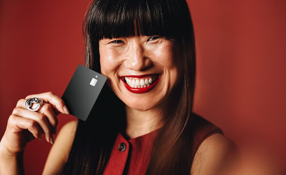 Woman holding credit card in studio portrait for banking and finance concept