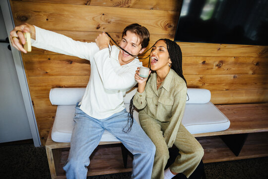 Two people enjoying playful moments in a relaxed indoor setting