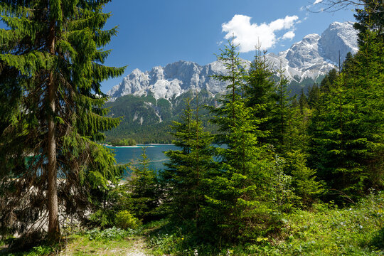 Travel landscape of Zugspitze Alps in Bavaria, Germany, scenic summer nature panorama with forest, Eibsee lake, snow mountains peak. Alpine landscape