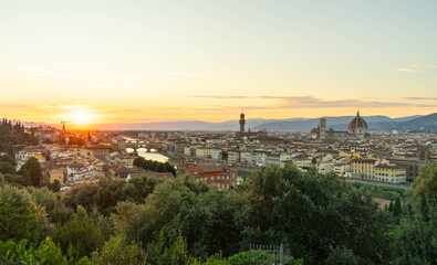 Fototapeta premium Vista panorámica de Florencia al atardecer con la catedral de Santa María del Fiore, el Ponte Vecchio y el río Arno desde un punto elevado.