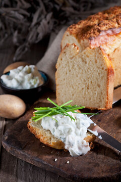 Slice of potato bread spread with herbed curd cheese