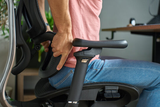 Man adjusting lumbar support on ergonomic office chair