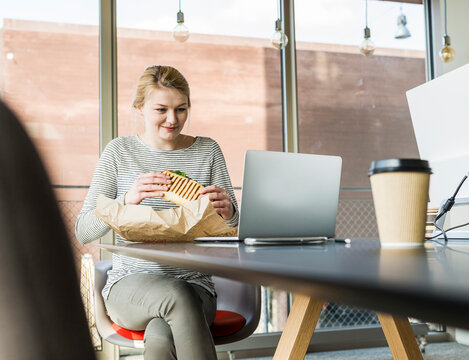 Young woman having lunch break in office 