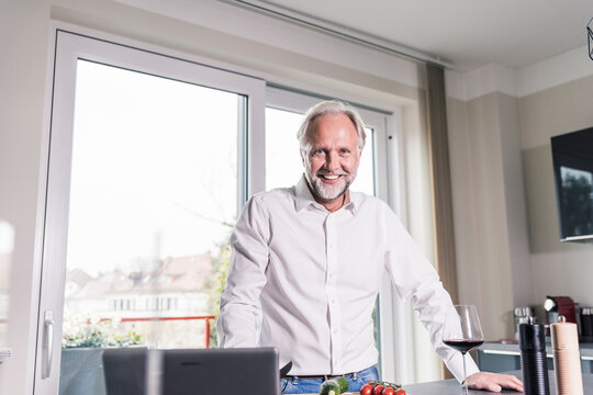 Portrait of relaxed mature man standing in the kitchen