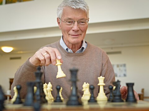 A senior man plays chess at a retirement home in Cologne