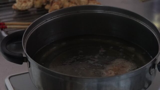 鶏のから揚げを揚げる女性