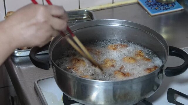 鶏のから揚げを揚げる女性