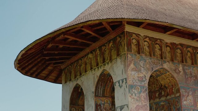 Humor Monastery in Bucovina Romania shows colorful old paintings on its walls. The unique architecture enhances the beauty of this historic site for all visitors.