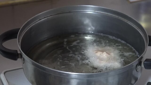 鶏のから揚げを揚げる女性