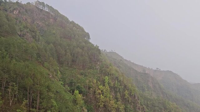 Scenic footage from the Manakamana cable car showing a passenger gondola traveling above densely forested mountain slopes