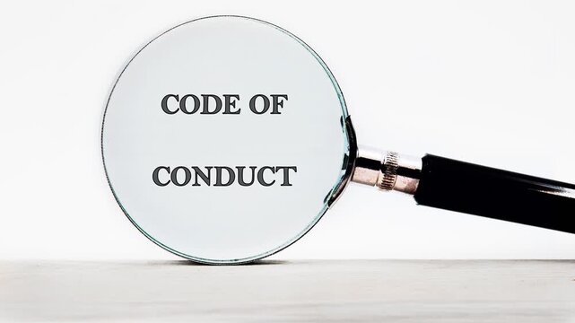 Magnifying glass revealing the text Code Of Conduct on a clean white background