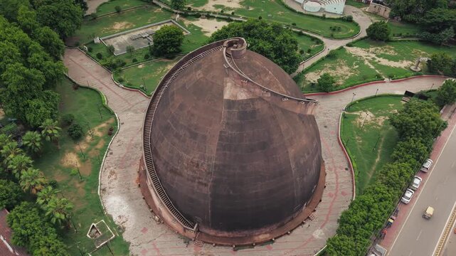 Aerial drone view of Golghar, a massive dome-shaped historic granary in Patna, Bihar, India. The iconic 18th-century monument is surrounded by lush greenery and the urban landscape of Patna