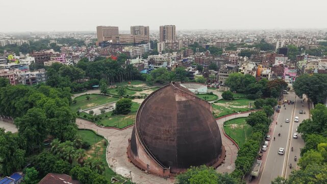 Aerial drone view of Golghar, a massive dome-shaped historic granary in Patna, Bihar, India. The iconic 18th-century monument is surrounded by lush greenery and the urban landscape of Patna