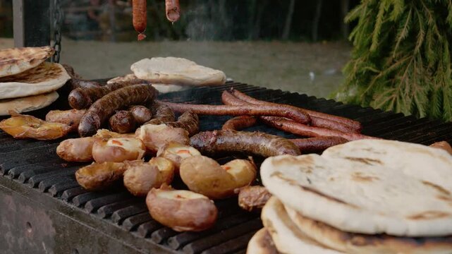 People gather to enjoy grilled potato and sausage pies at a street food festival in Bukovina. The delicious food is prepared fresh on a hot grill outdoors.
