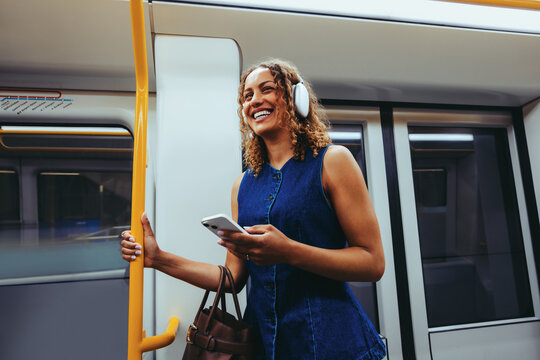 Happy woman uses smartphone on the train during her commute