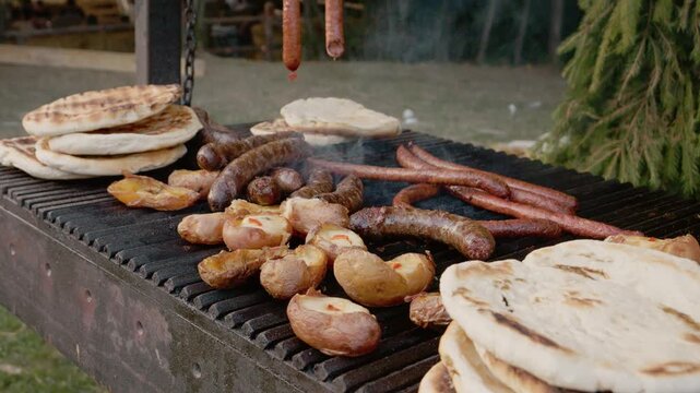 At a festival in Bukovina, people enjoy grilled potato and sausage pies. The aroma of cooking fills the air while tasty food sizzles on the grill.