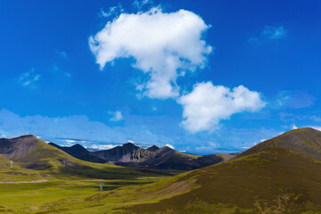 Obraz premium Tibetan Plateau Landscape with Green Hills and Blue Sky