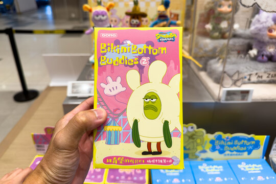 PENANG, MALAYSIA - JUL 03, 2026: Hand holding SpongeBob SquarePants Bikini Bottom Buddies blind box inside Pop Mart retail store.
