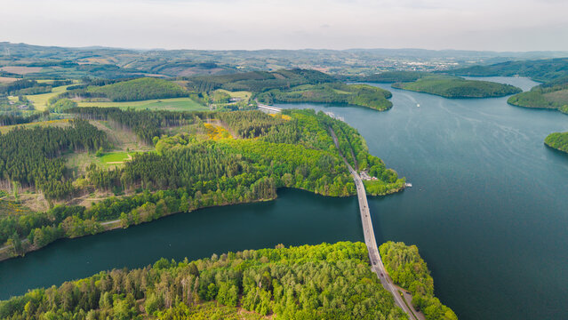 Aerial panorama of Biggesee reservoir with bridge and forested islands in Germany