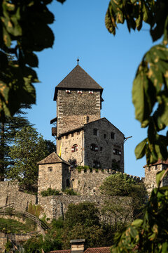 Medieval Branzoll Castle Framed by Foliage in Chiusa - South Tyrol, Italy