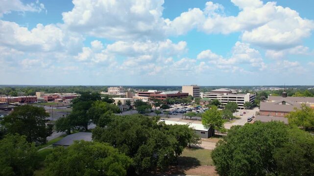 Aerial drone footage of Downtown Conroe, Texas, featuring the James H. Keeshan Building and Montgomery County Courthouse, with surrounding downtown buildings, streets, parking areas, and railroad trac