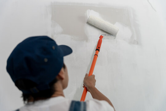 painter man, brush in hand for products to restore and paint the wall, indoor the building site of a house, wall during painting, renovation, painting, contractor, Architect, construction worker