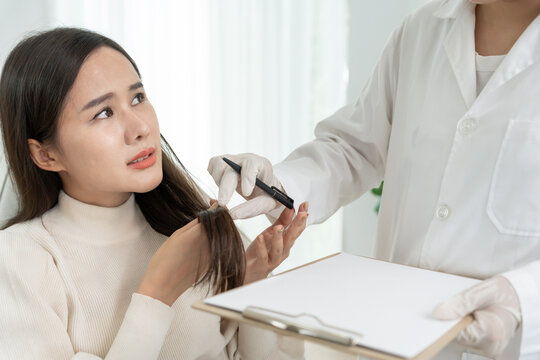 Specialist of hair recheck hair of Asian woman, damaged hair, hair loss, thinning problem, vitamin deficiency, baldness, postpartum, biotin, zinc, menstrual or endocrine disorders, hormonal imbalanc