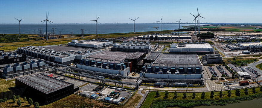 Eemshaven, Groningen, Netherlands - 13 August 2026: Aerial view of the Google data center complex with large industrial buildings, cooling systems, and wind turbines.