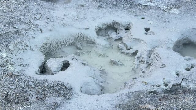 Iceland. Colorful geothermal landscape with steaming blue water and mineral-rich earth, showcasing a series of rocky formations and wooden walkways in a natural hot spring area