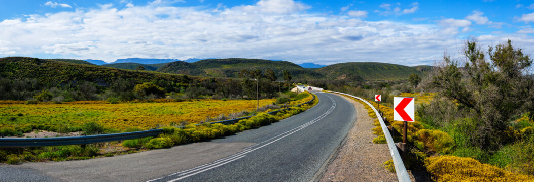 Scenic view of the R62 winding through the Little Karoo and crossing the Groot River near Ladismith in the Western Cape, South Africa, a spectacular route through rugged mountains and arid scenery.