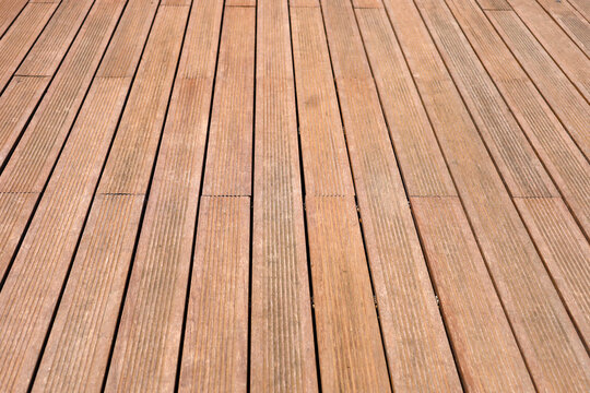 Dark brown composite wooden deck flooring planks.