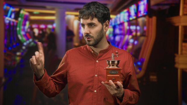 Man holding coffee grinder with finger to lips for silence in a casino building; secrecy hush intrigue.