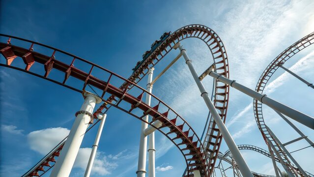 Roller coaster loop from low angle against blue sky, thrilling amusement park ride, dynamic perspective, adventure tourism concept, extreme entertainment attraction