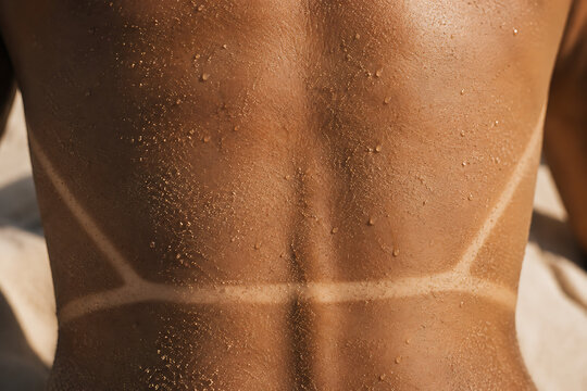 Woman&rsquo;s Tanned Back with Bikini Tan Lines, Sand and Water Drops