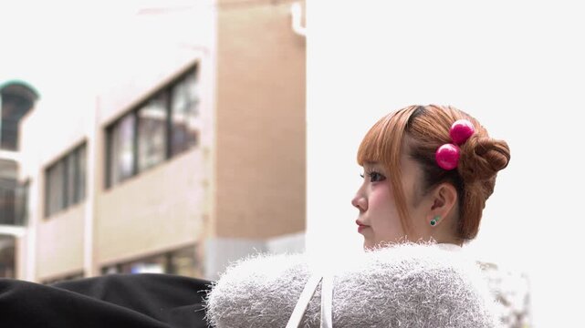 Japanese Woman with Orange Hair and Space Buns Turning in Tokyo