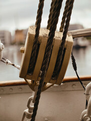 Close-up of weathered wooden block and tackle with ropes on a ship in  © Marcin