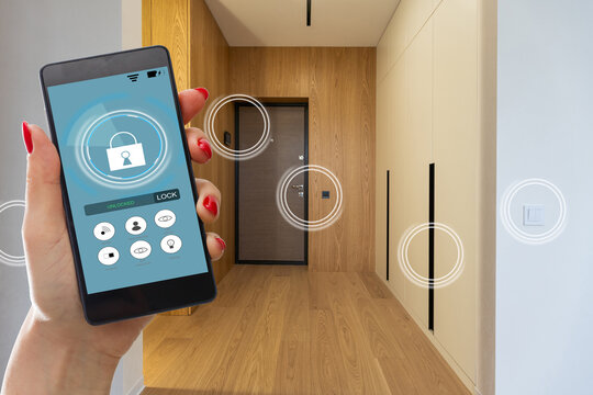 man hand holding phone with app smart home in room house