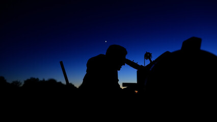 Amateur astronomer observing stars, planets, Moon and other celestial objects with a telescope in nature. © astrosystem