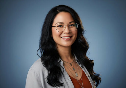 Portrait of a charming young asian woman wearing glasses standing down the street and looking at the camera.