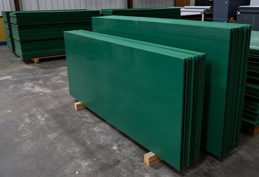 Sustainable building materials and green construction, stacked recycled plastic lumber sheets in a warehouse for eco-friendly projects