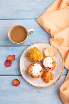 Сhoux pastry cake with cup of coffee on blue wooden, close up, top view.
