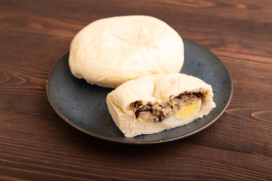 Vietnamese steamed buns Banh bao on brown wooden. side view, close up