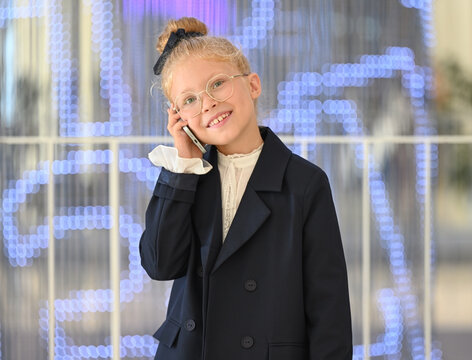 Portrait of a little girl smiling happily and talking on the phone
