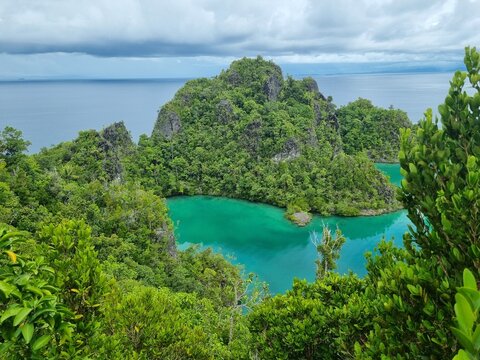 Dramatic storm clouds over Pianemo tropical limestone islands viewpoint in Raja Ampat, Indonesia, epic moody seascape before the rain
