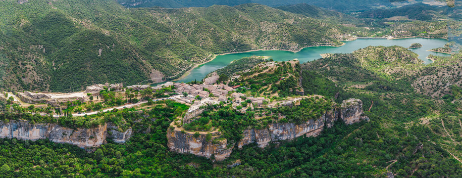 Aerial view of Siurana village perched on towering cliffs above Siurana Reservoir in Catalonia, Spain.