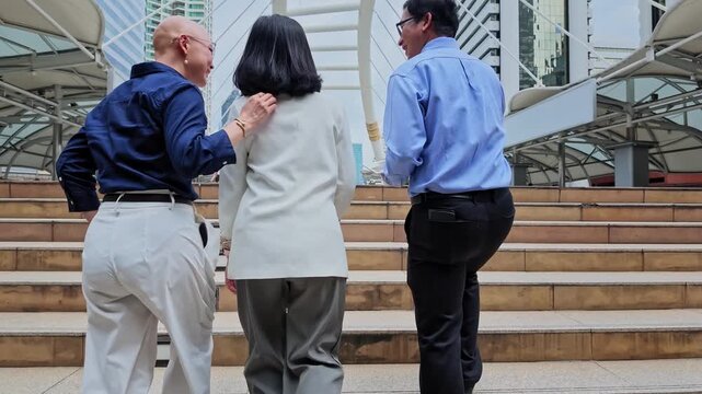 Group of three people walking together in urban setting with modern architecture and cityscape background
