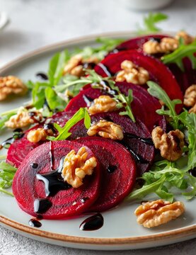 Fresh gourmet beetroot salad with arugula and walnuts on plate